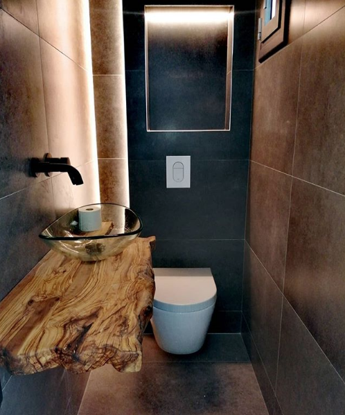 Aseo de cortesía de diseño con encimera de madera maciza orgánica y grifo empotrado en Poble Sec Barcelona