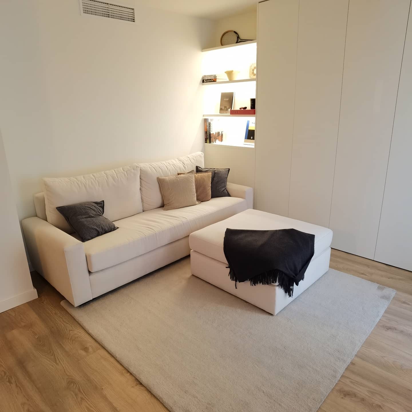 Reforma de salón principal en tonos neutros con iluminación indirecta y almacenaje a medida en Sarrià Barcelona
