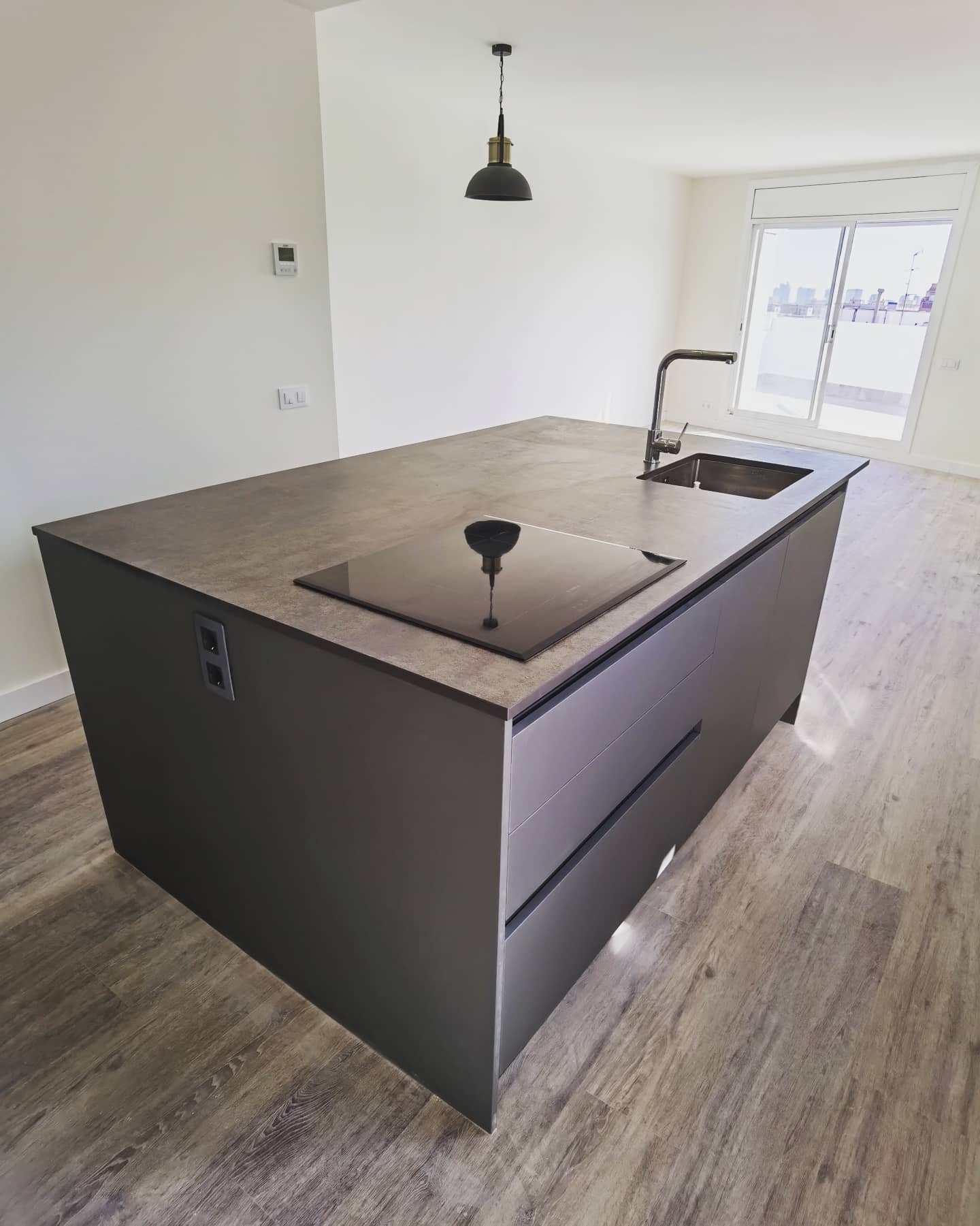 Isla de cocina moderna equipada con placa de inducción y fregadero en Sant Andreu Barcelona