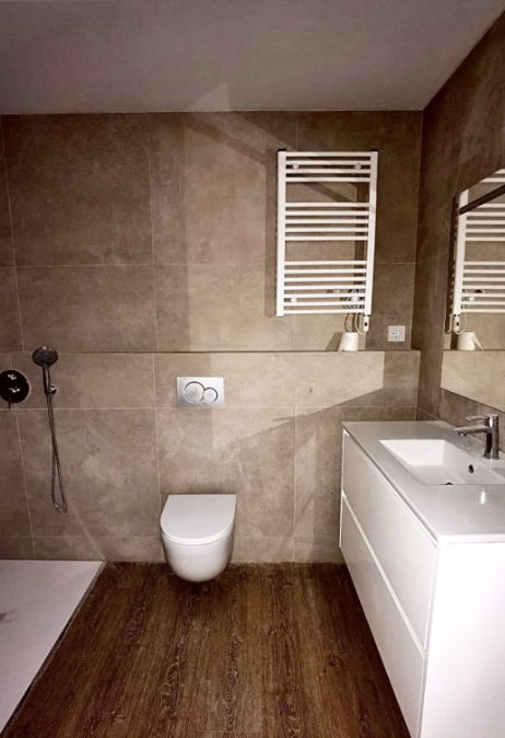 Reforma de baño moderno con inodoro suspendido, mueble blanco a medida y toallero radiador en Sarrià Barcelona
