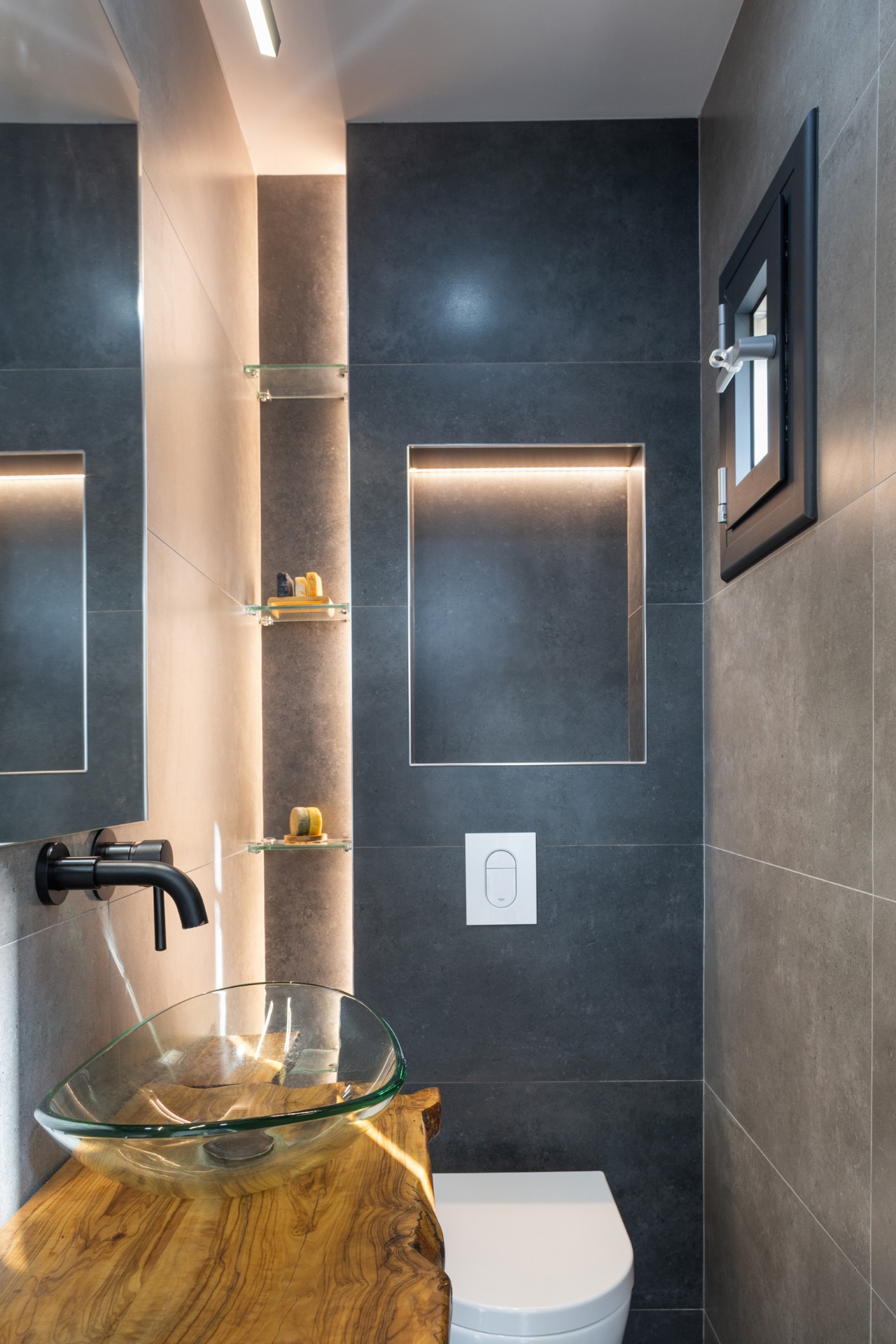 Aseo de cortesía de diseño con encimera de madera maciza orgánica y grifo empotrado en Poble Sec Barcelona