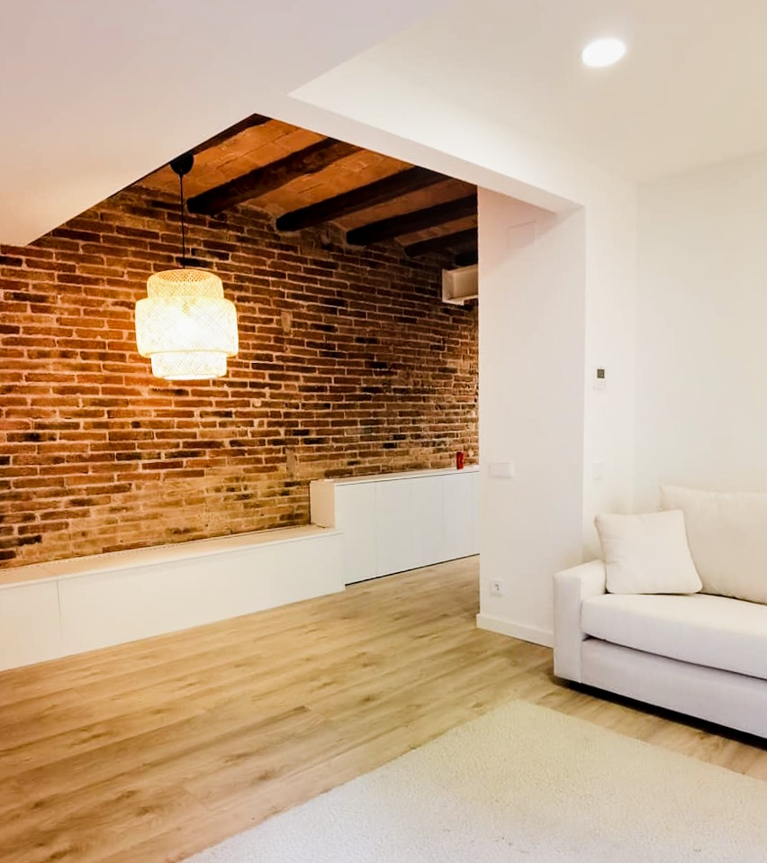 Reforma integral pared ladrillo visto vigas madera barcelona